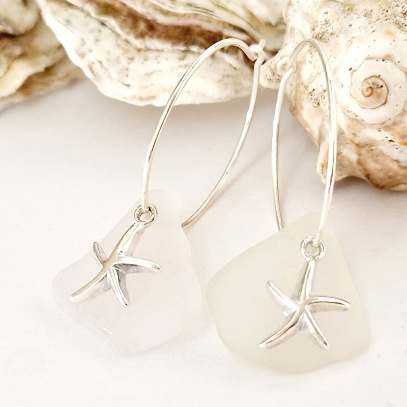 Ocean Start Hoop Earrings presented next to eachother and with sea shells in the background