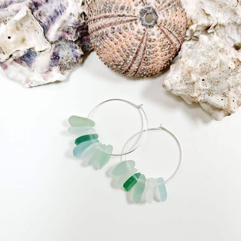 Sea glass waterfall earrings presented with sea shells