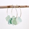 Omea Waterfall Sea Glass Earrings hanging on wooden stick