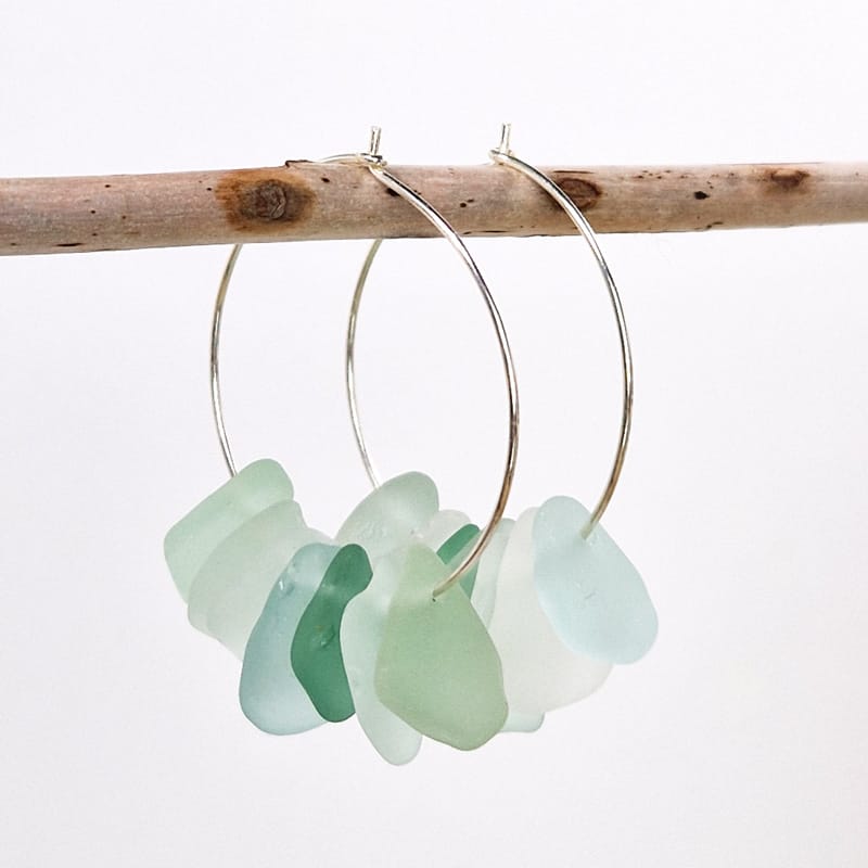 Omea Waterfall Sea Glass Earrings hanging on wooden stick